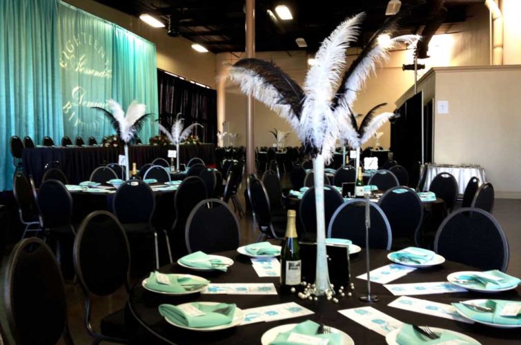 Feather center pieces with black table and chairs in event space