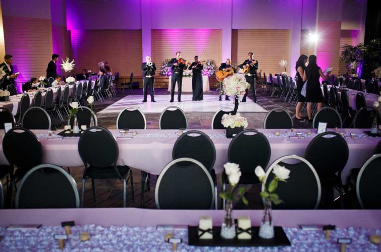 Live band with purple accent lighting and tables with chairs