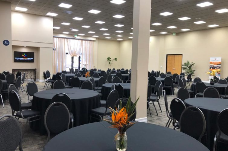 event space with black tables, chairs, and flower centerpieces