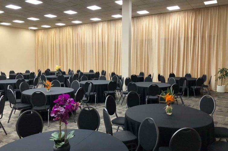 event room with tables, chairs, and flower centerpieces