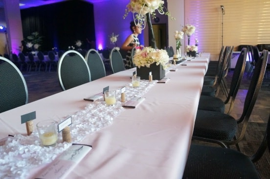 flowers and candles on the tables and chairs setting for the wedding event