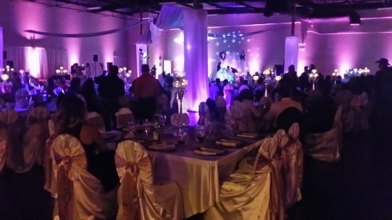 tables, chairs, and people standing at the wedding event