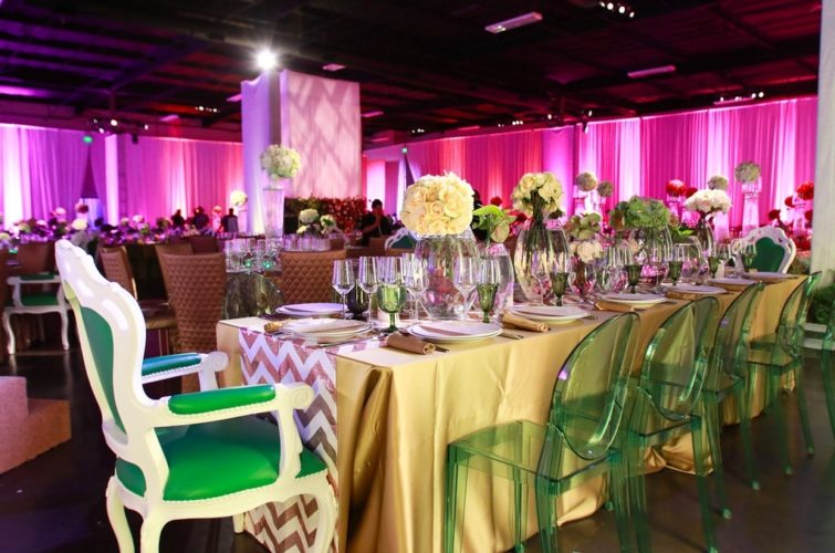 flowers and plates setting on the tables with chairs at TSE Wedding Gala 2015