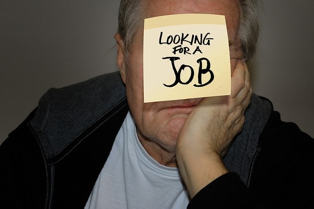 Man with post-it note on his forehead that says "looking for a job." 