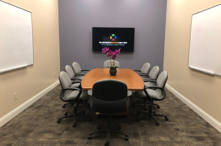 corporate meeting room with table, chairs, tv, and whiteboards